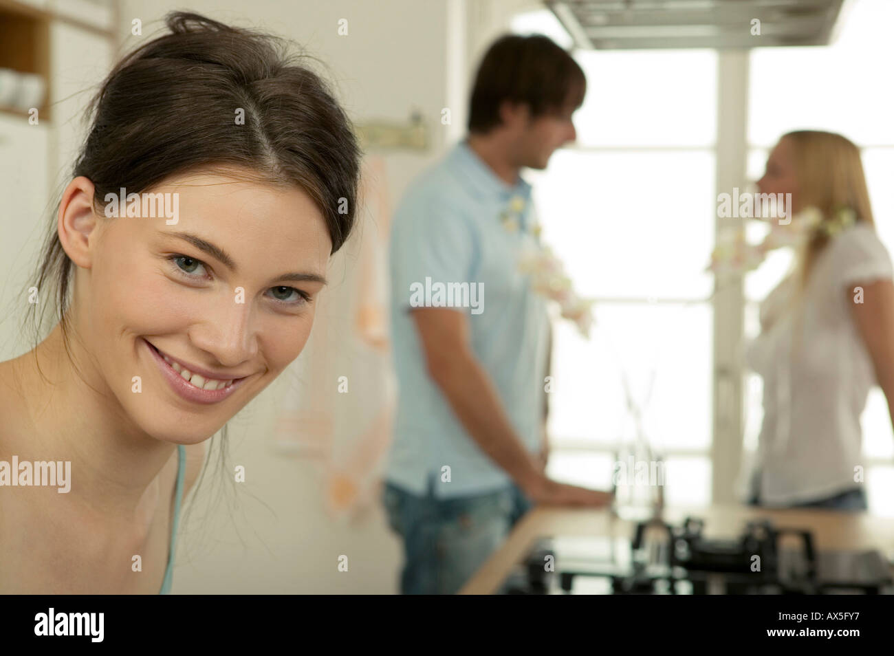 Woman smiling, portrait, couple in background Stock Photo - Alamy