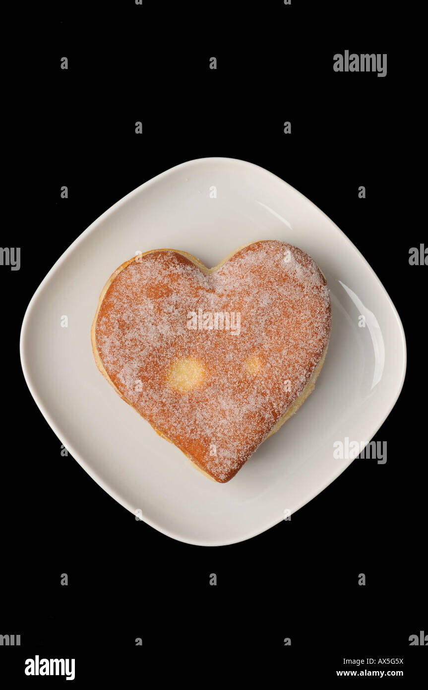 Heart-shaped Berliner (jelly-filled donut) on a plate Stock Photo