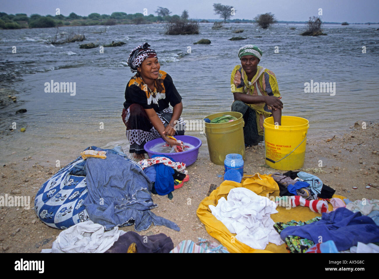 Women washing clothes and having a chat, Nyumba ya Mungu, Kilimanjaro Region, Tanzania. Stock Photo