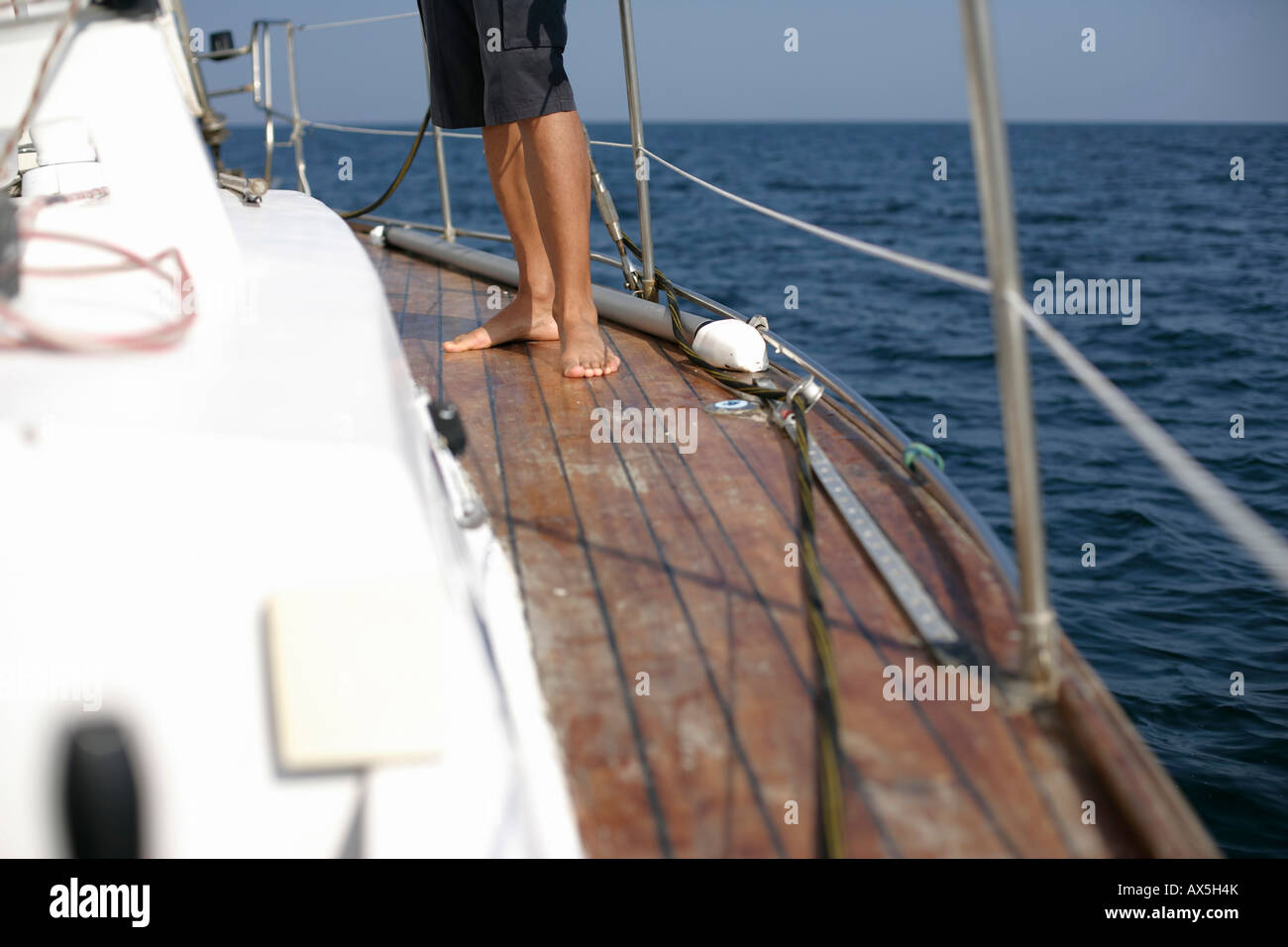 Man standing on the deck of a sailboat, focus on feet Stock Photo - Alamy