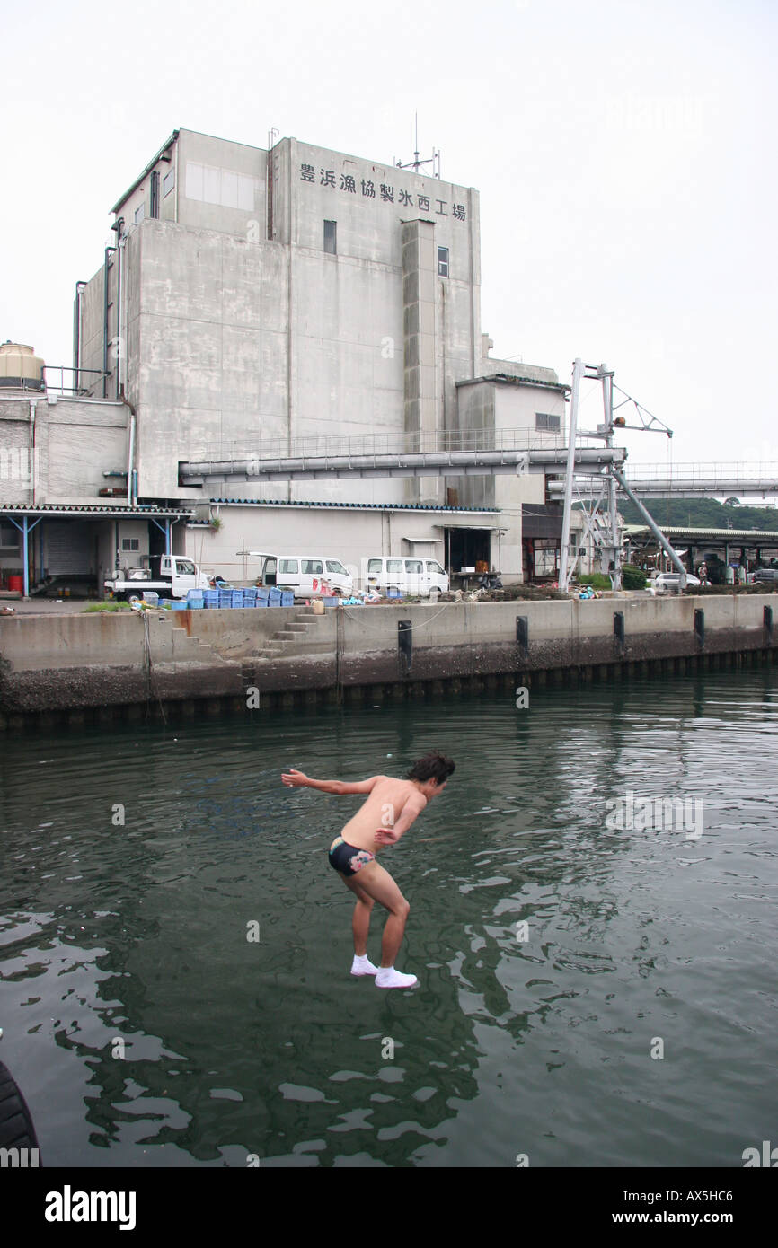 Young man jumping into the sea during a festival in Japan fishing town Stock Photo