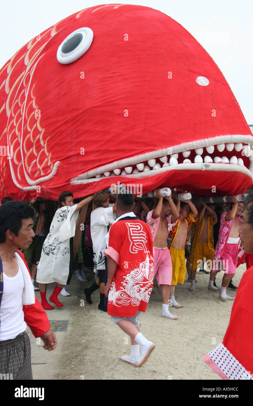 Men lift a giant fish float at a summer festival in Japan Stock Photo