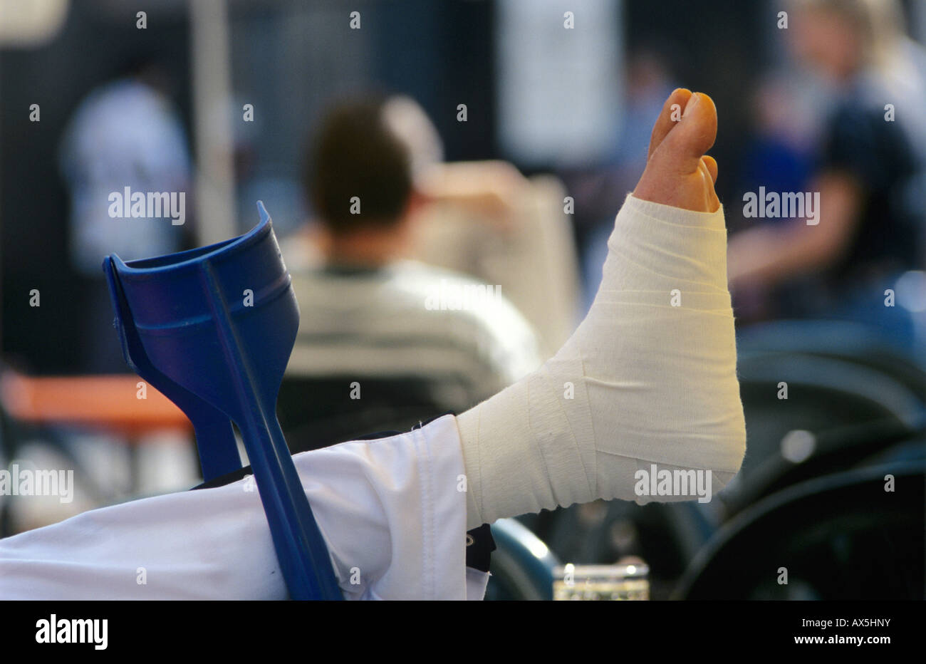 Bandaged foot put up on crutches in a cafe Stock Photo