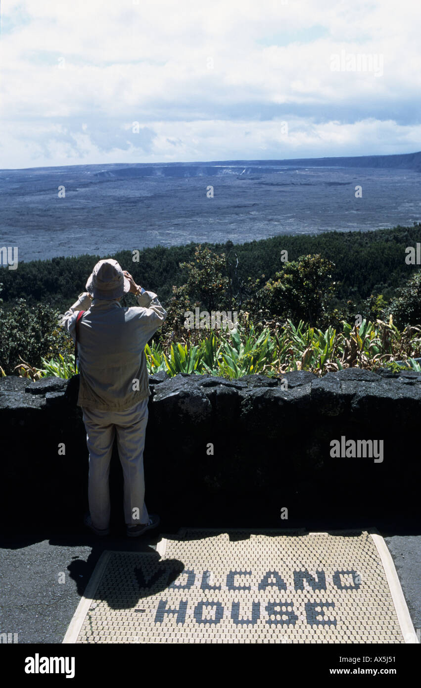 Kona Island, Hawaii, USA. Tourist with binoculars looking over the Kilauea volcano crater on a mat 'Volcano House'. Stock Photo