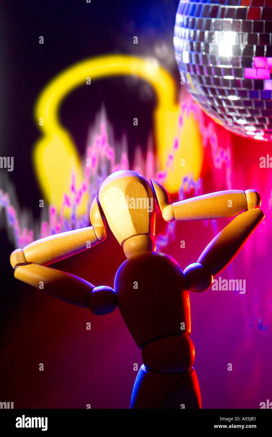 Wooden artist mannequin with hands on ears, glitterball in background signalling loud noise danger. Stock Photo