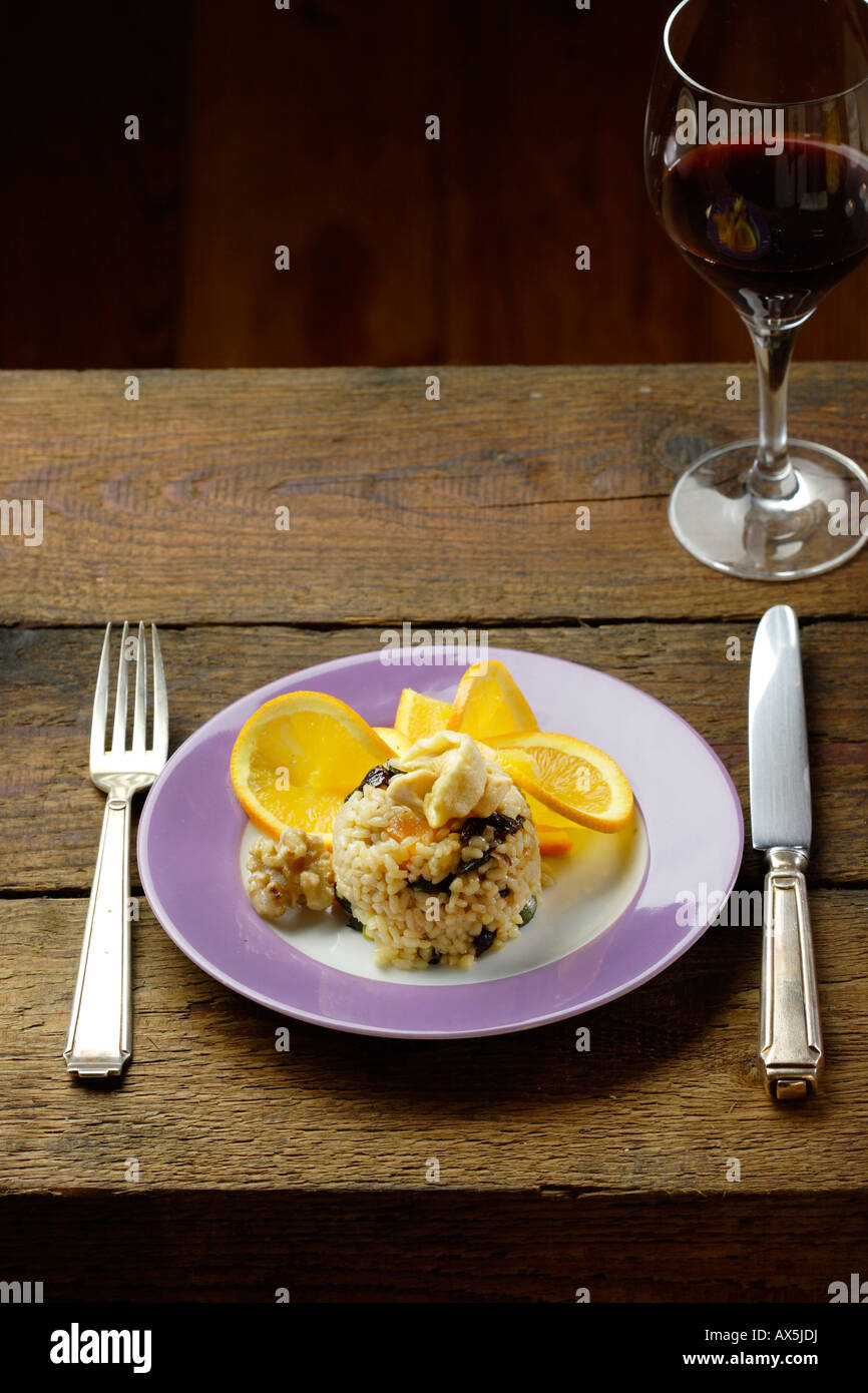 Risotto with dried fruit and candied walnuts. Arranged with slices of orange Stock Photo