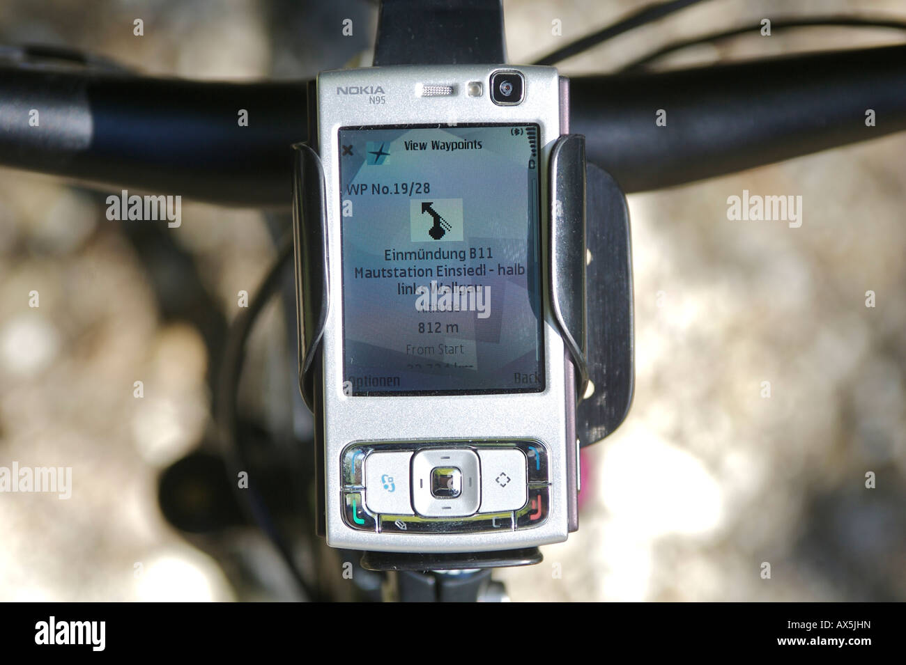 Mobile GPS unit on mountain bike handlebars, monitors showing the way