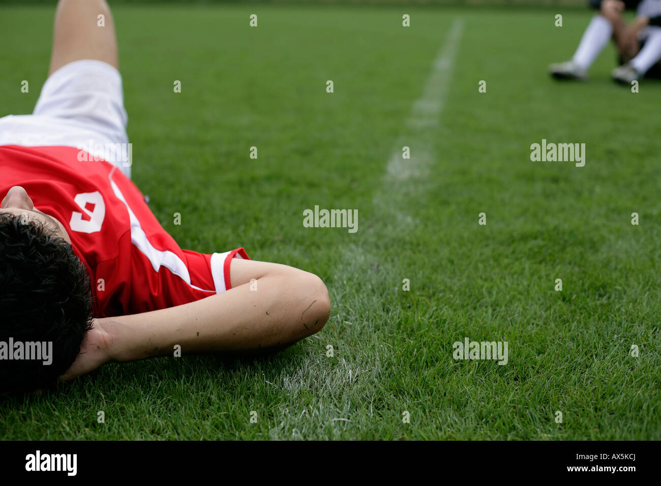 Soccer player lying on grass Stock Photo Alamy