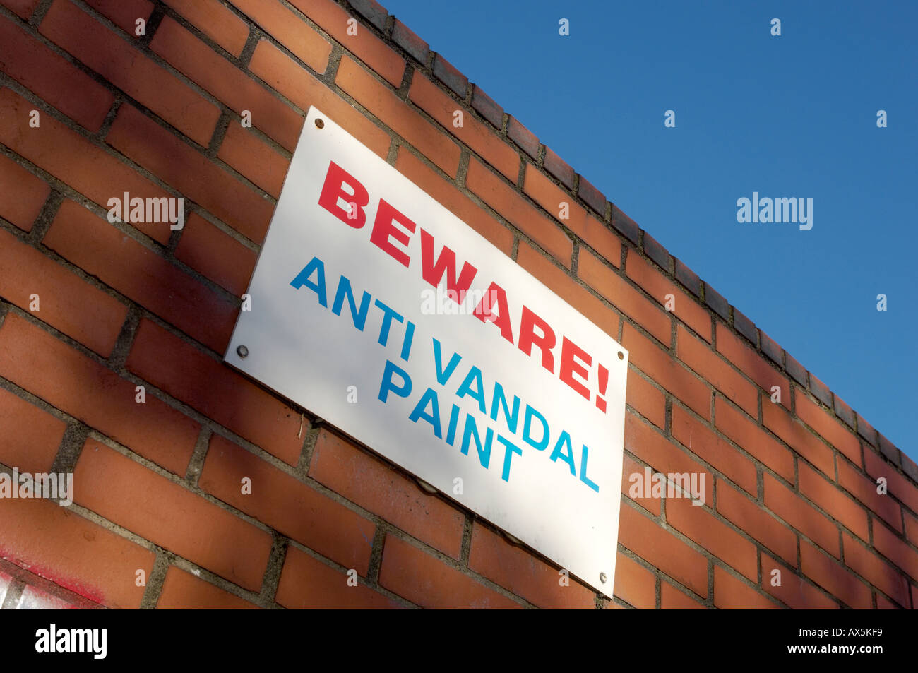Beware Anti Vandal Paint sign mounted on a brick wall seen against a