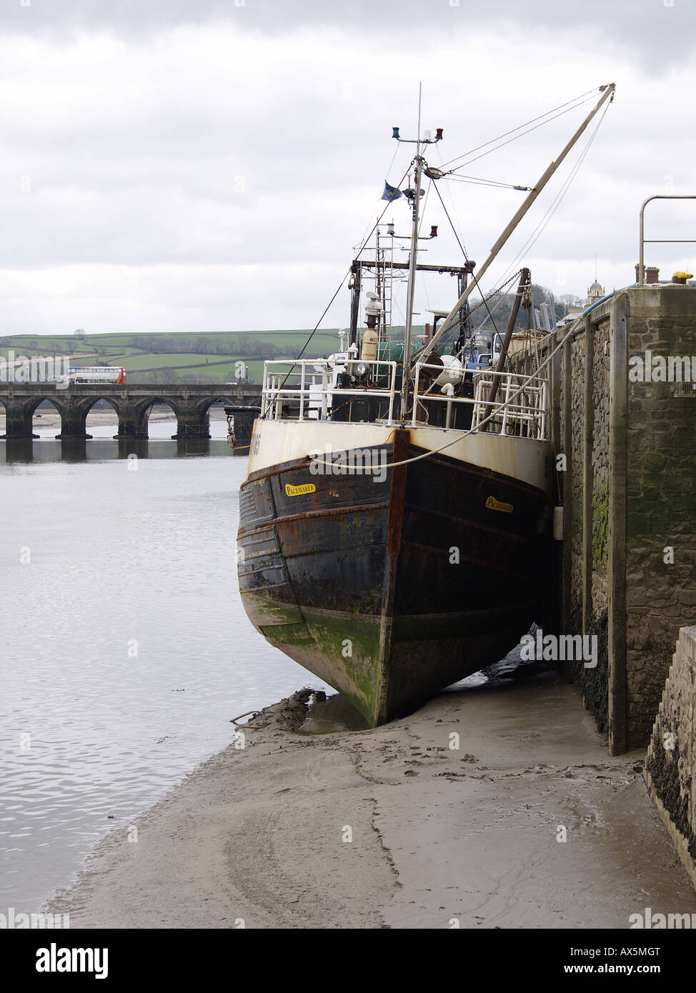 Large fishing trawler at low tide leaning against harbour wall Bideford North Devon U K Stock Photo