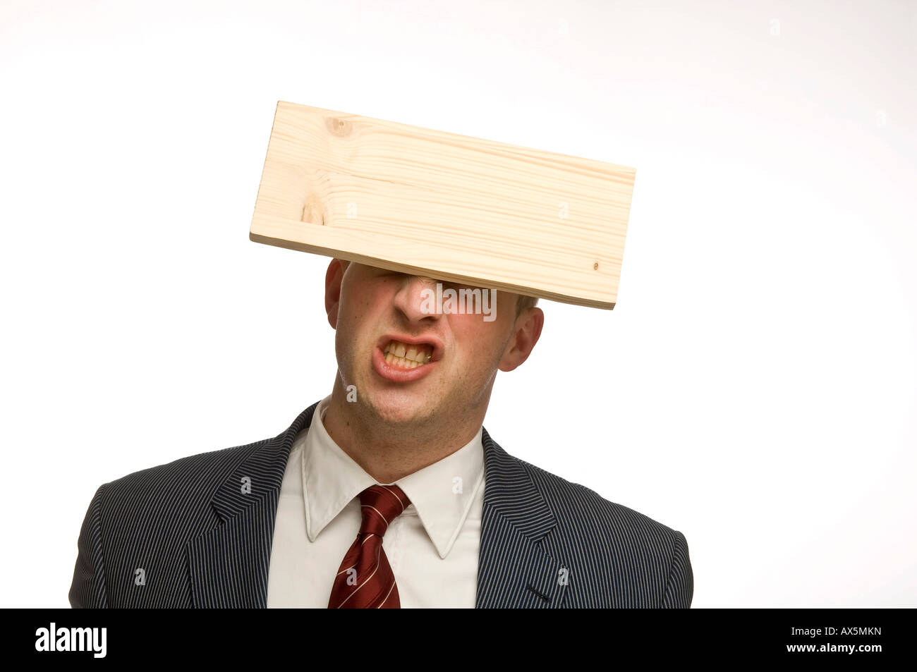 Young man balancing a wooden board on his forehead Stock Photo