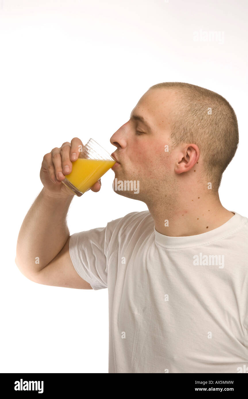 Young Man Drinking A Glass Of Orange Juice Stock Photo Alamy