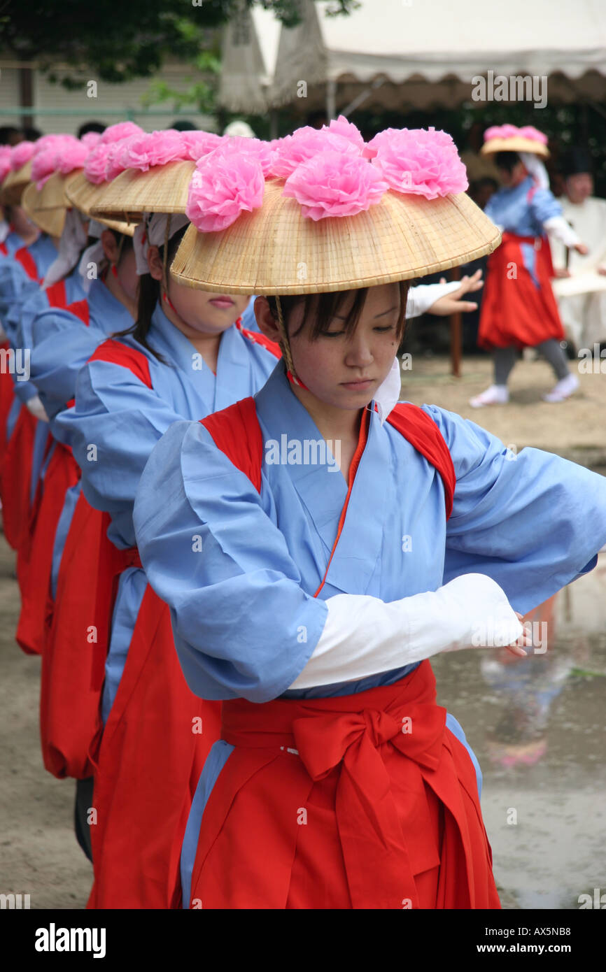 Young women dance around a rice field during a ritual harvest festival in Japan Stock Photo