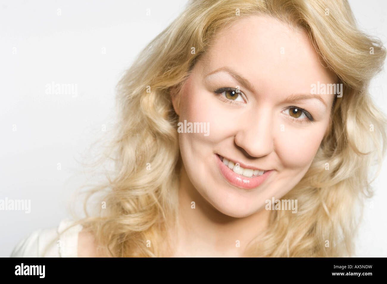 Portrait of a laughing young blonde woman looking straight ahed Stock Photo