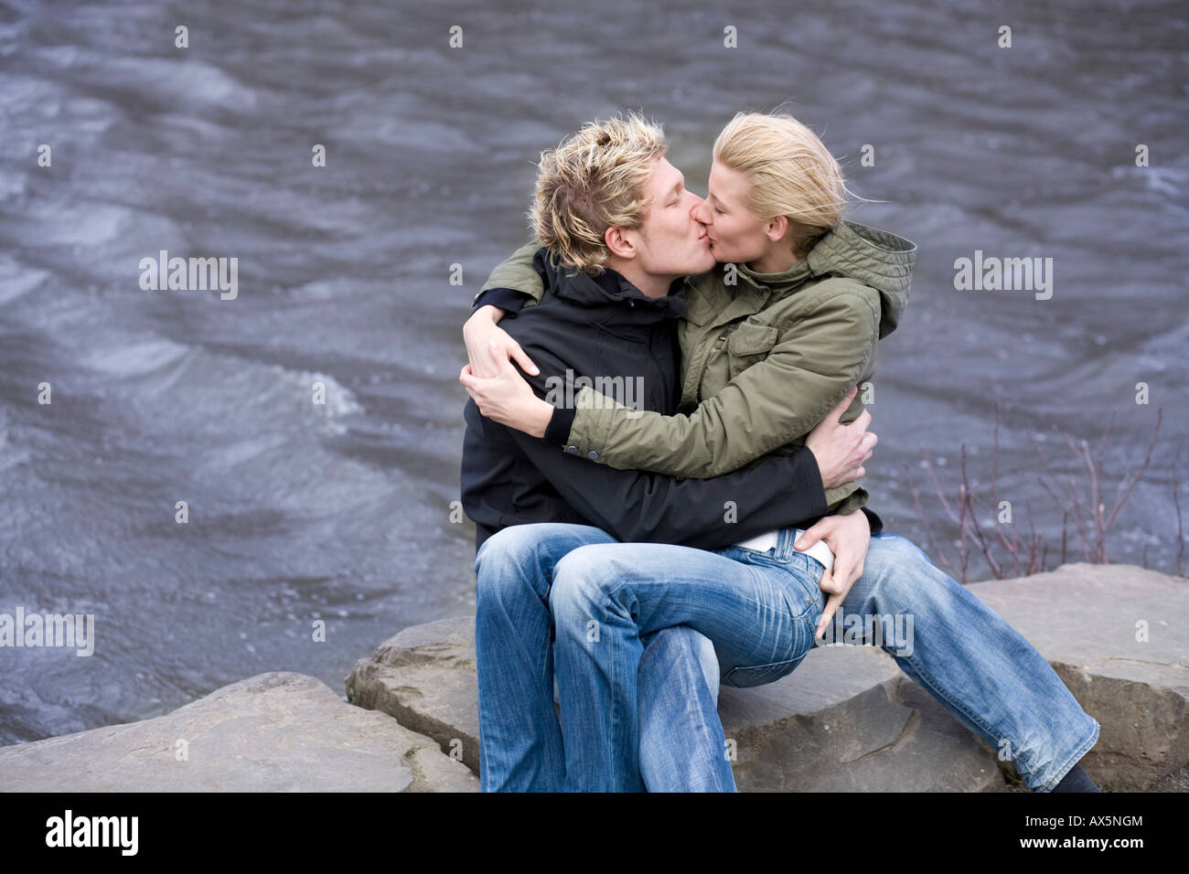 Couple kissing in front of water Stock Photo