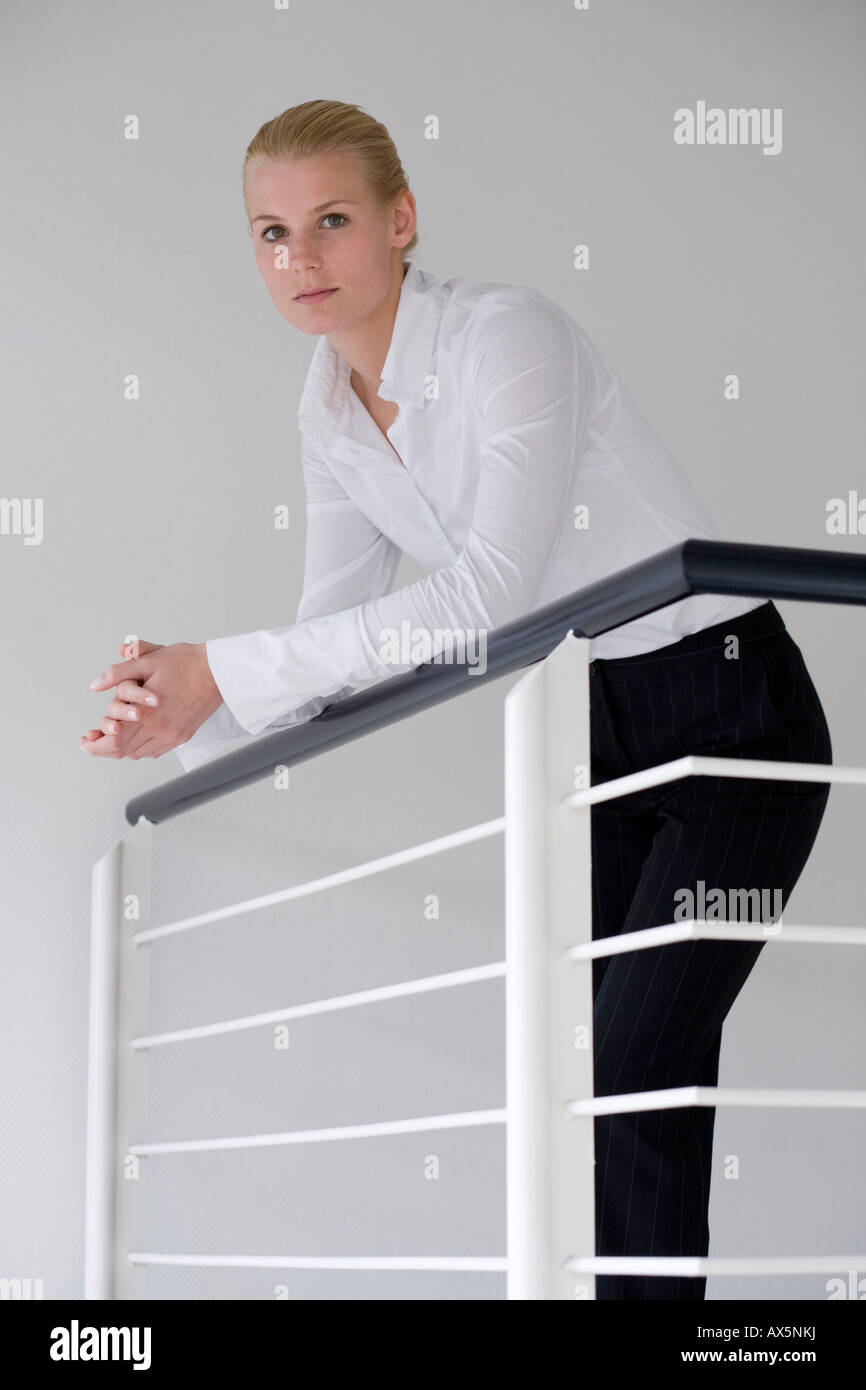 Blonde businesswoman leaning against a railing Stock Photo