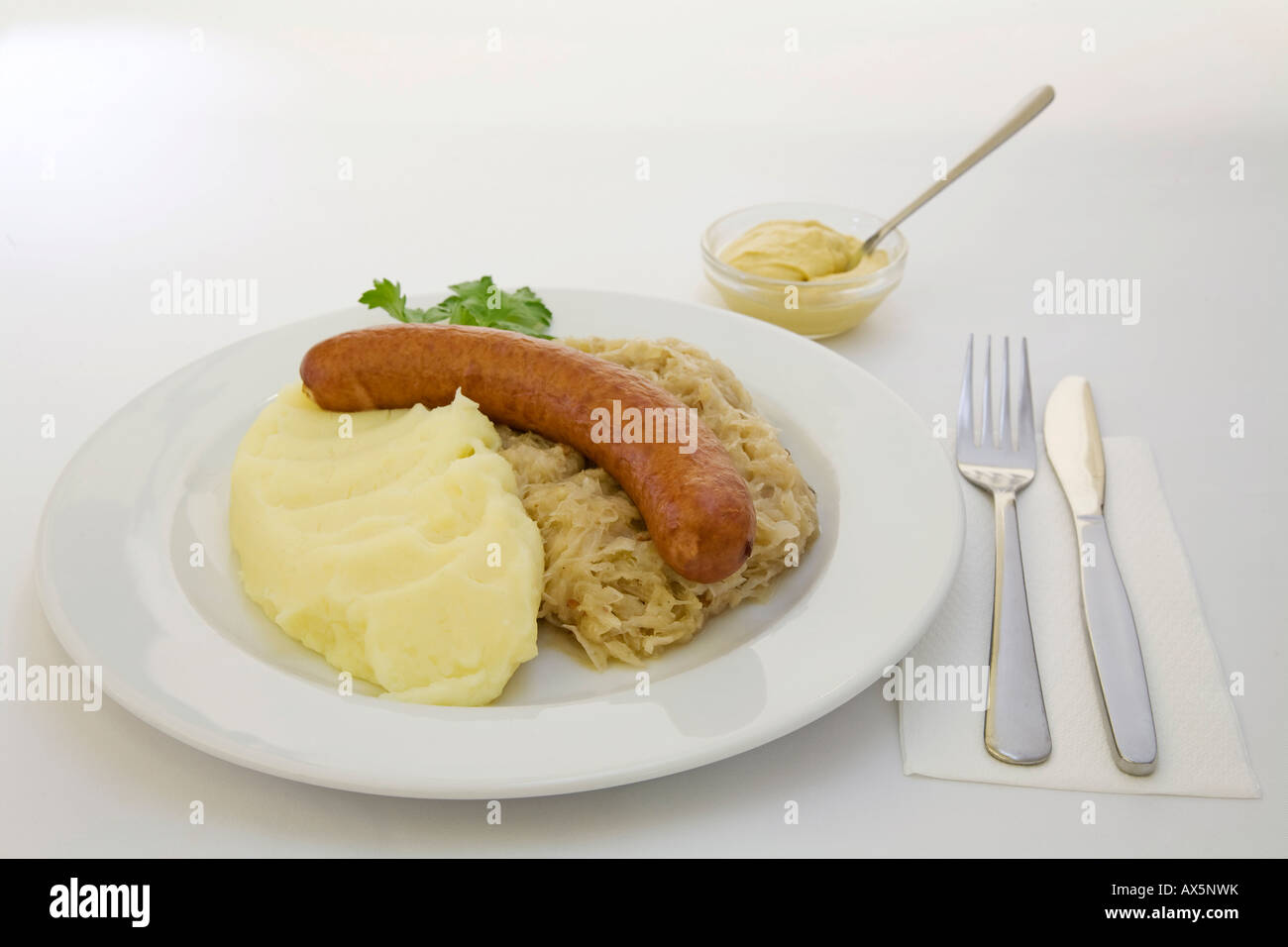 Mettwurst sausage, sauerkraut, mashed potatoes and mustard Stock Photo
