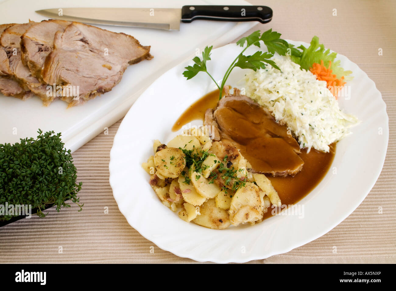 Pork roast with gravy, coleslaw and roasted potatoes Stock Photo