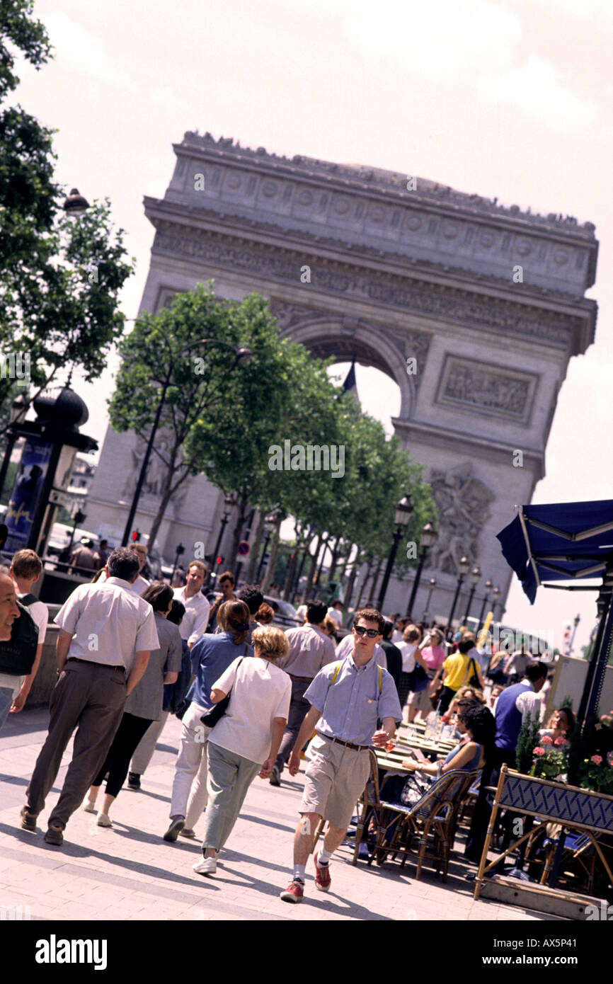 tourists walking on the Champs Elysees Paris France with Arc de Triumphe Stock Photo