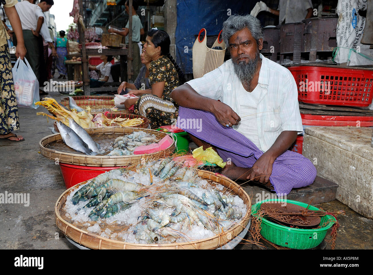 Fish vendor sitting behind baskets filled with fresh crabs in Yangon (Rangoon), Myanmar (Burma), Southeast Asia Stock Photo