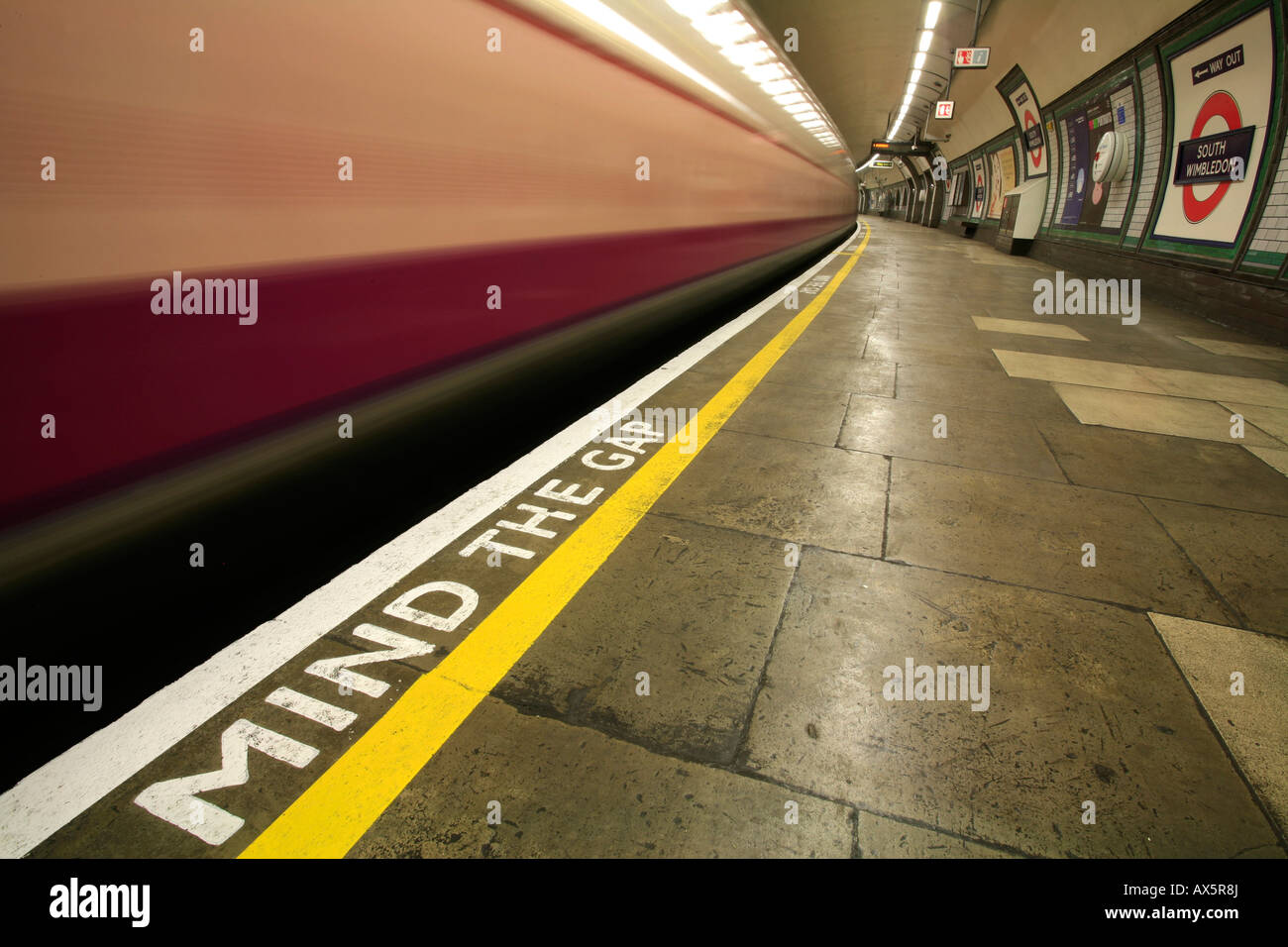 Mind the Gap - safety reminder and train coming through South Wimbledon underground station, London, England, UK, Europe Stock Photo