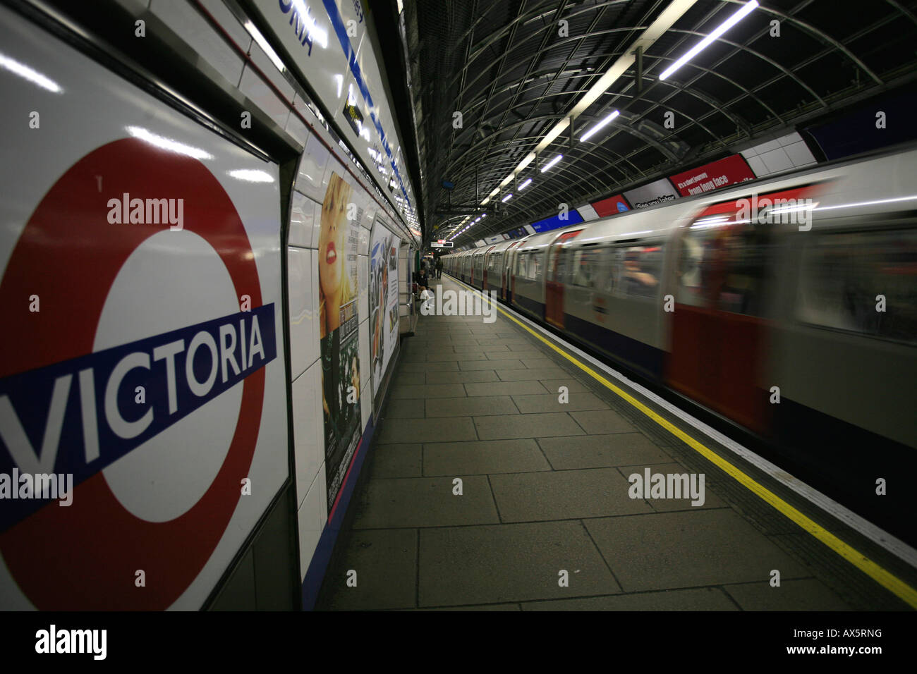Tube logo and train arriving at Victoria underground station, London