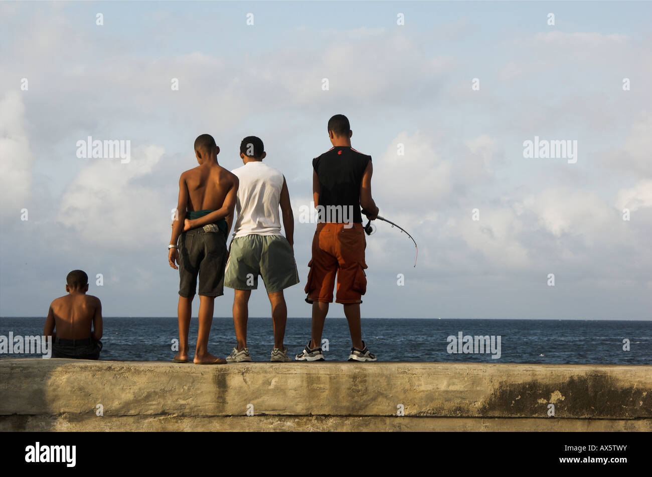 Cuban youths fishing from the Malecón, Havana, Cuba, Caribbean Stock Photo