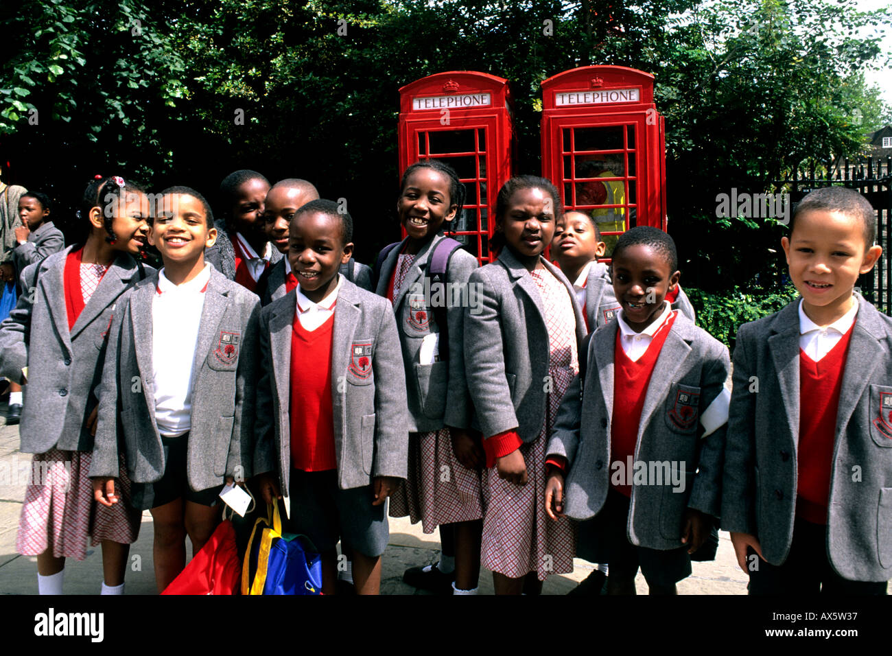 school children in uniform by red English telephone booth in London England Stock Photo Alamy