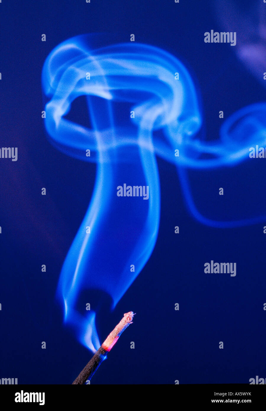 Smoke rising from an incense stick Stock Photo