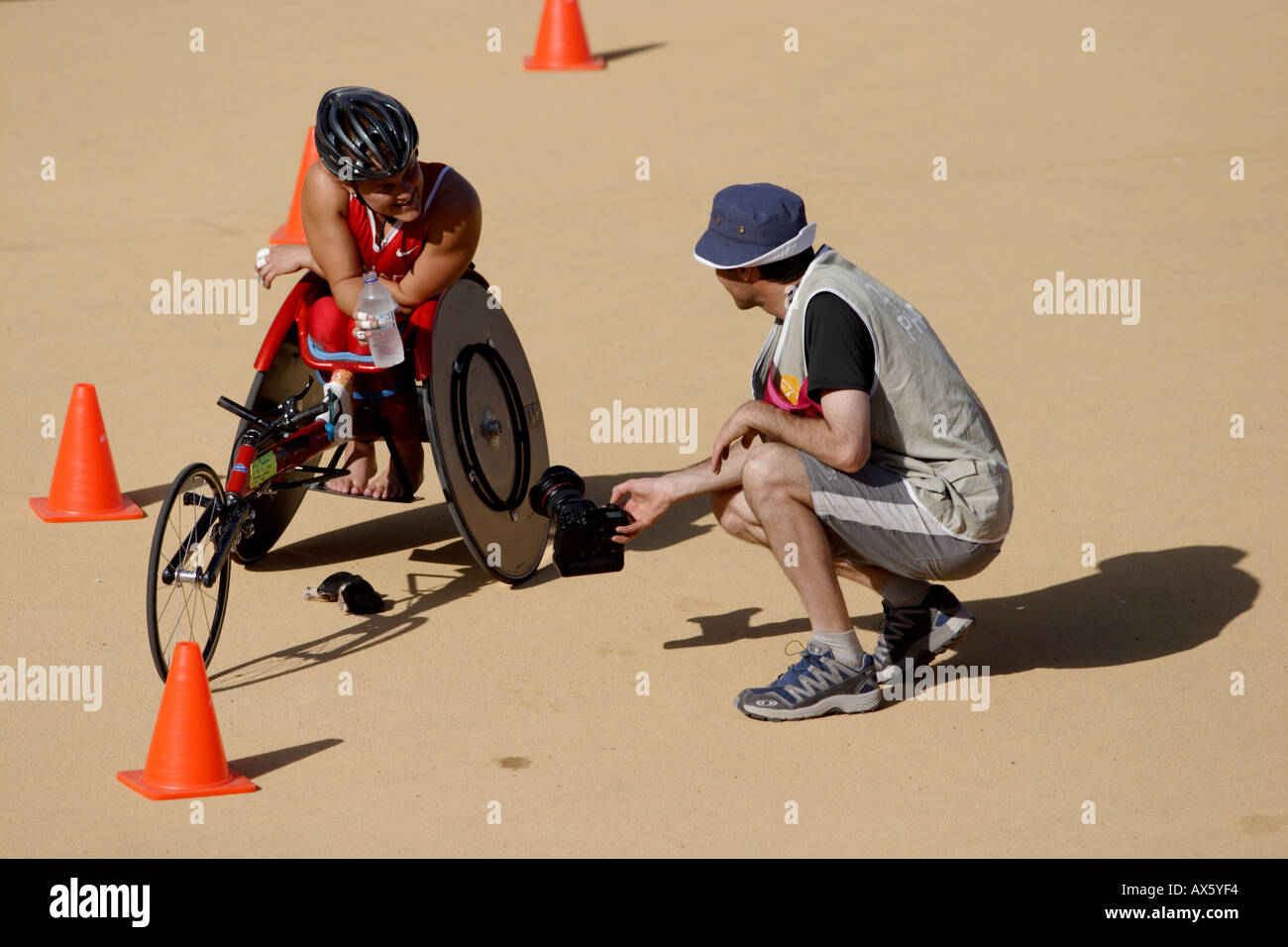 Photographer chats to and photographs an unknown female wheelchair athlete after the womens T54 category marathon Stock Photo