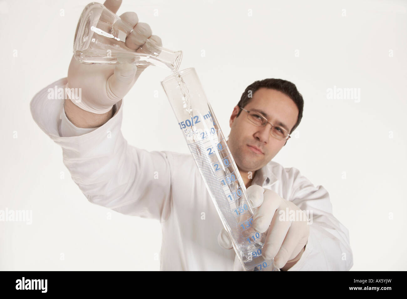 Chemist pouring liquid into a flask Stock Photo