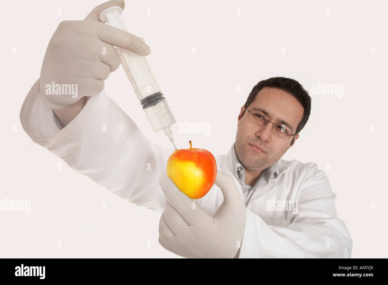 Chemist injecting a substance into an apple Stock Photo