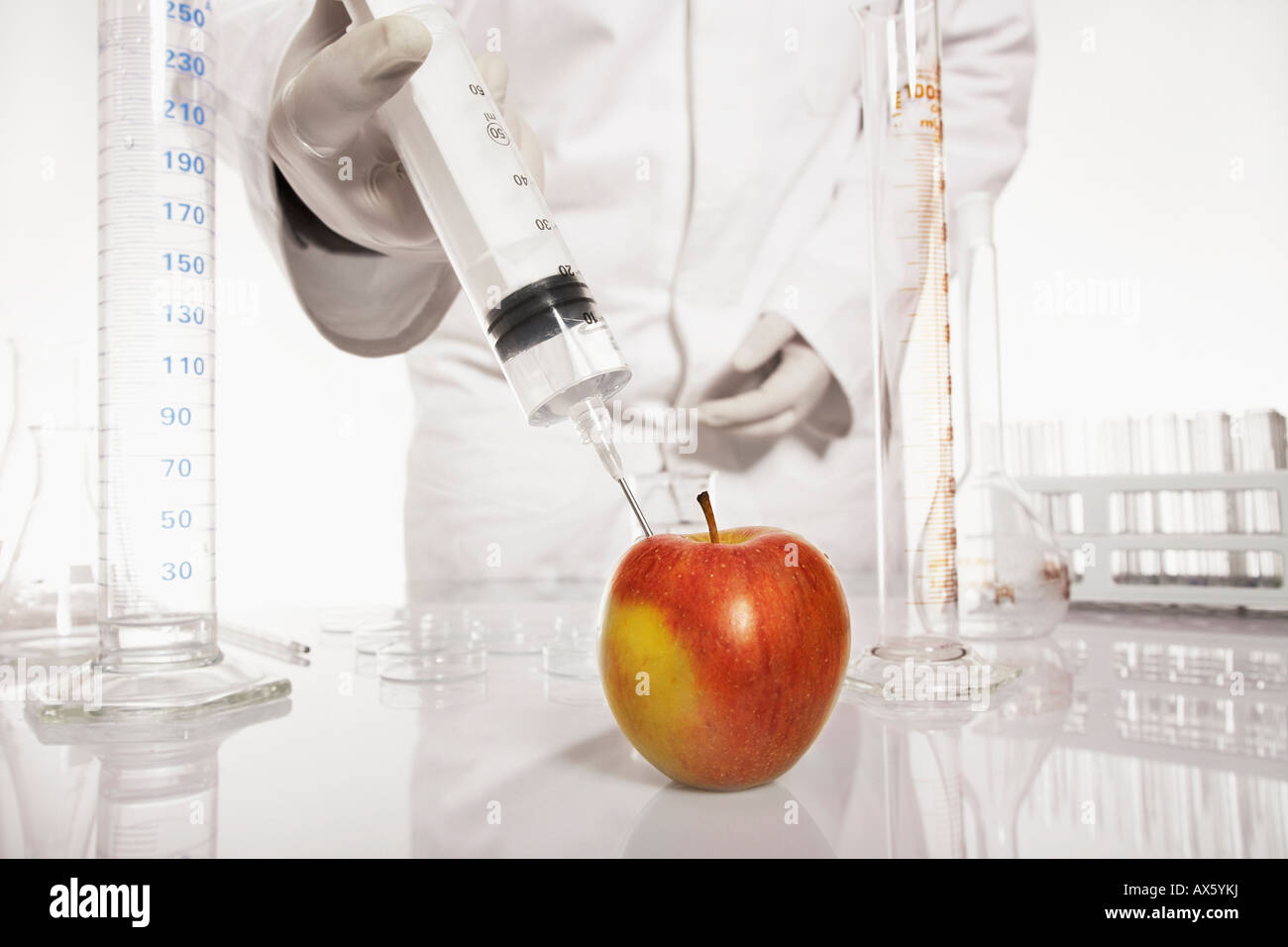 Chemist injecting a substance into an apple Stock Photo