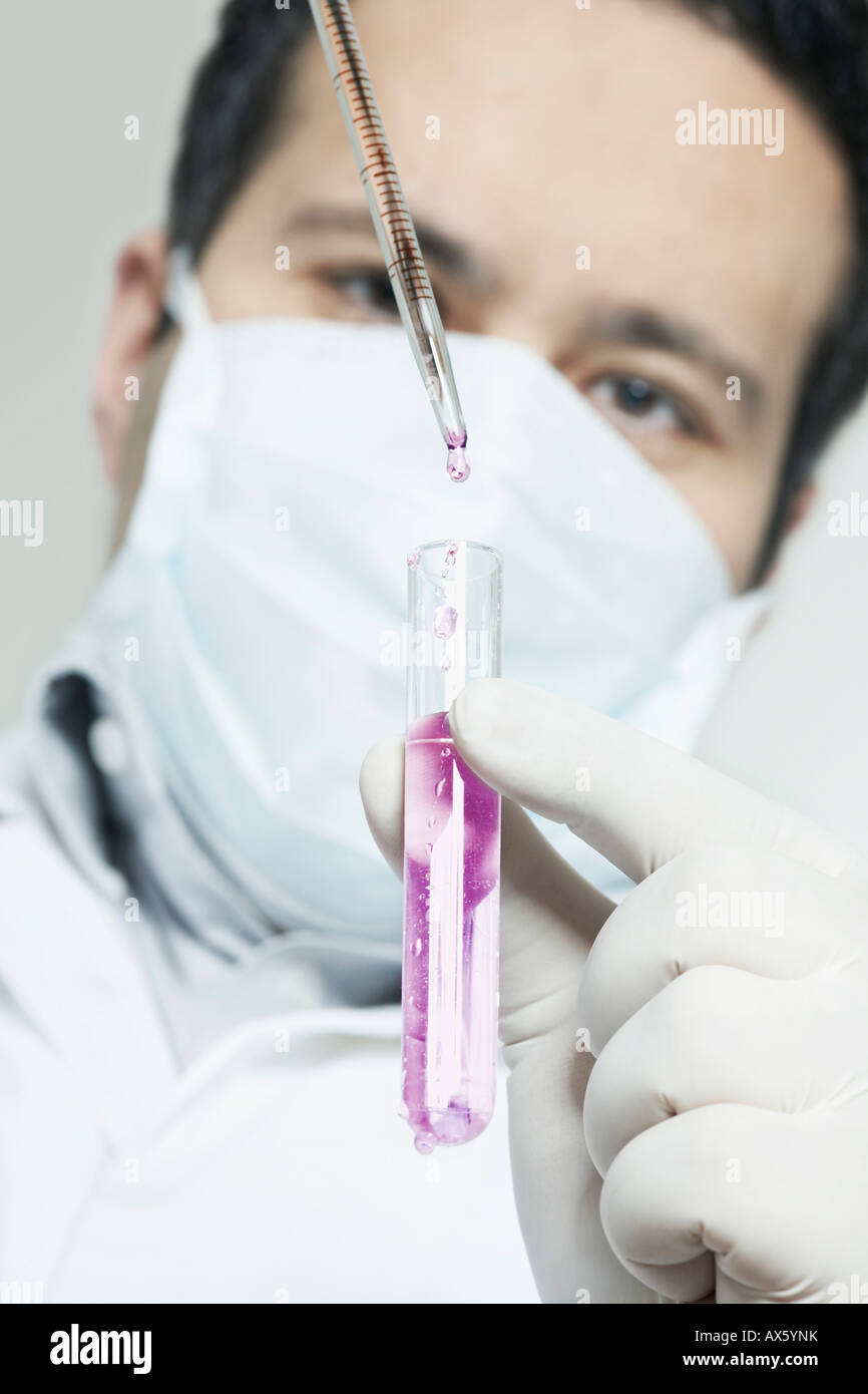Chemist filling substance into a test tube with pipette Stock Photo