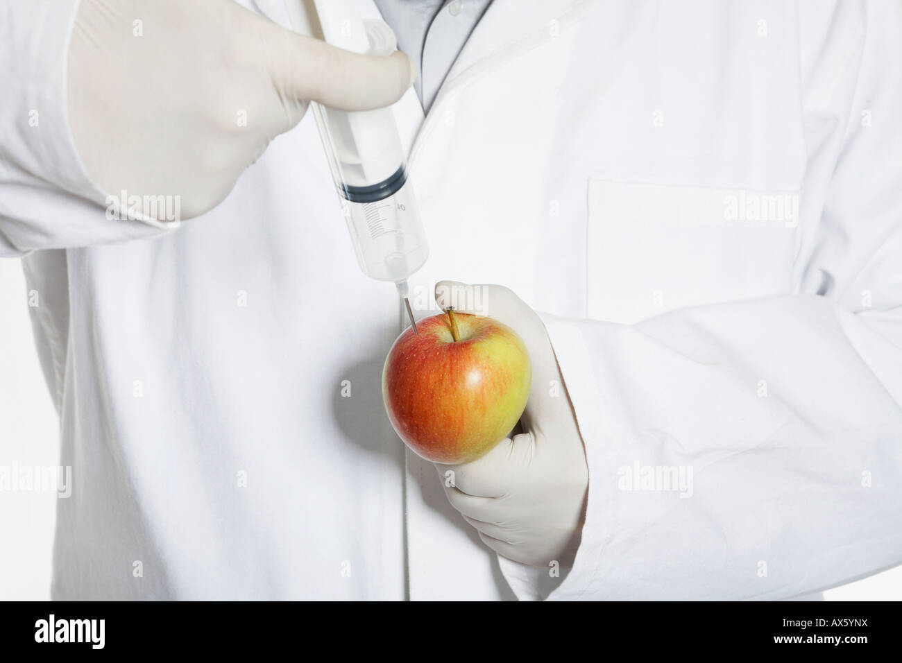 Chemist injecting substance into an apple Stock Photo