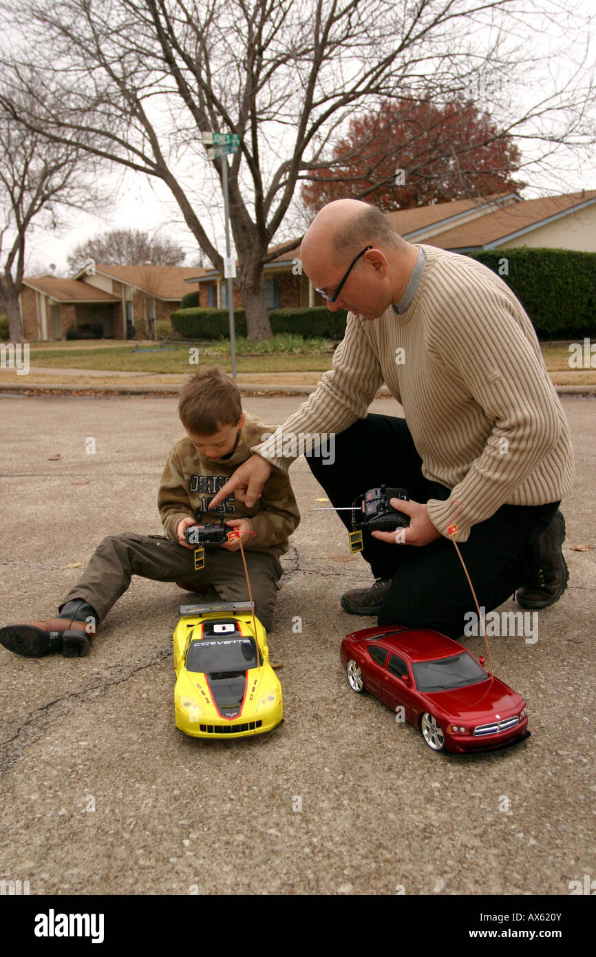 father and son with remote control racing cars in street Stock 