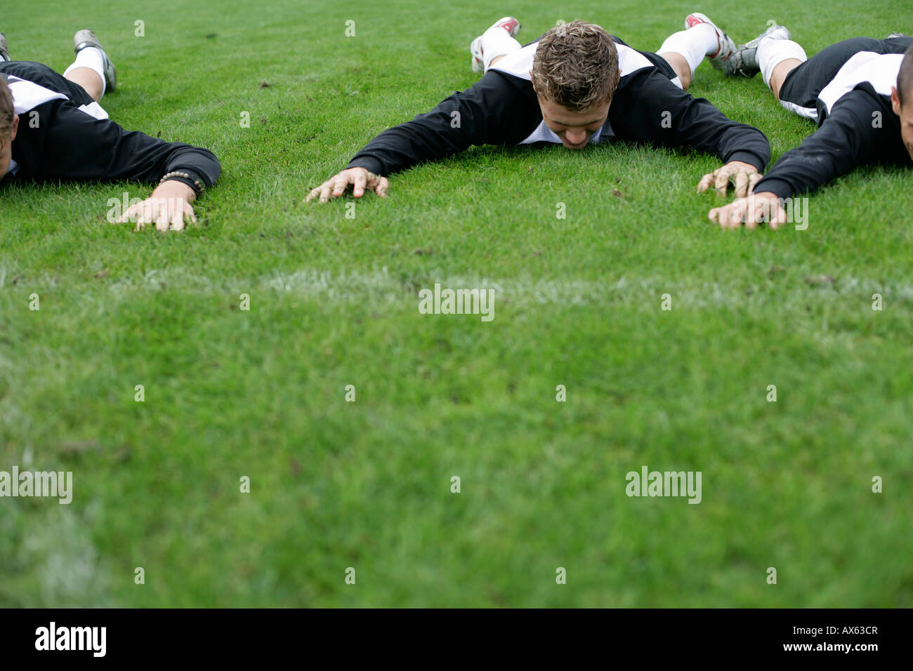 Soccer player lying on his stomach on grass Stock Photo Alamy