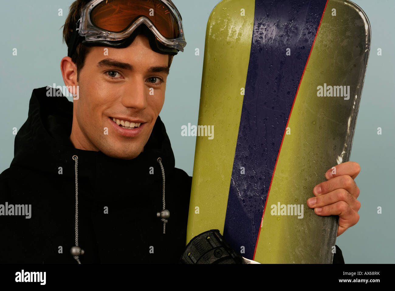 Portrait of a man holding a snowboard Stock Photo - Alamy