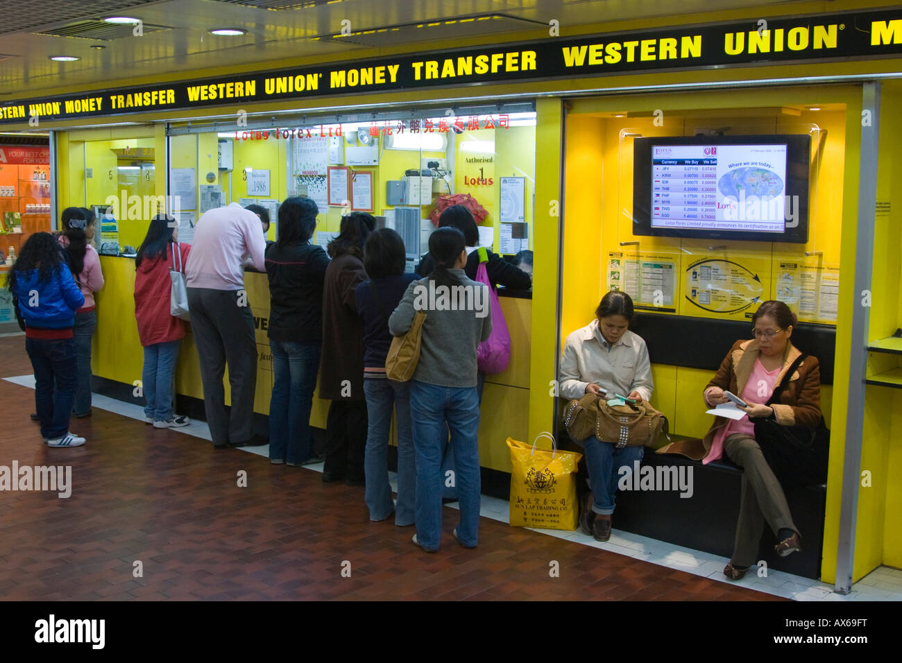 Filipina Amahs Sending Money Back to the Philippines with Western Union in Hong Kong Stock Photo