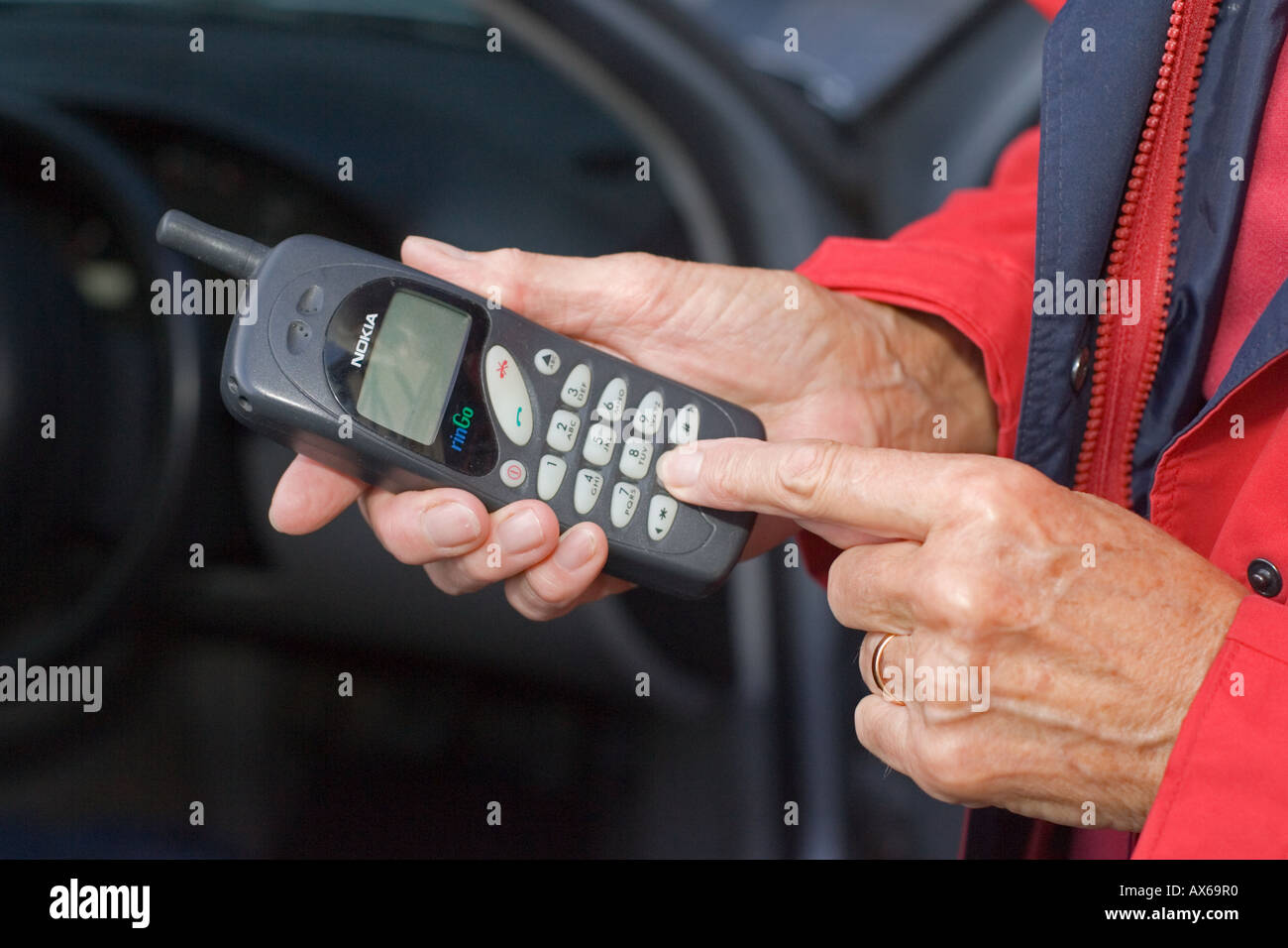 Close up of womans hands dialing on old Nokia mobile phone UK Stock Photo