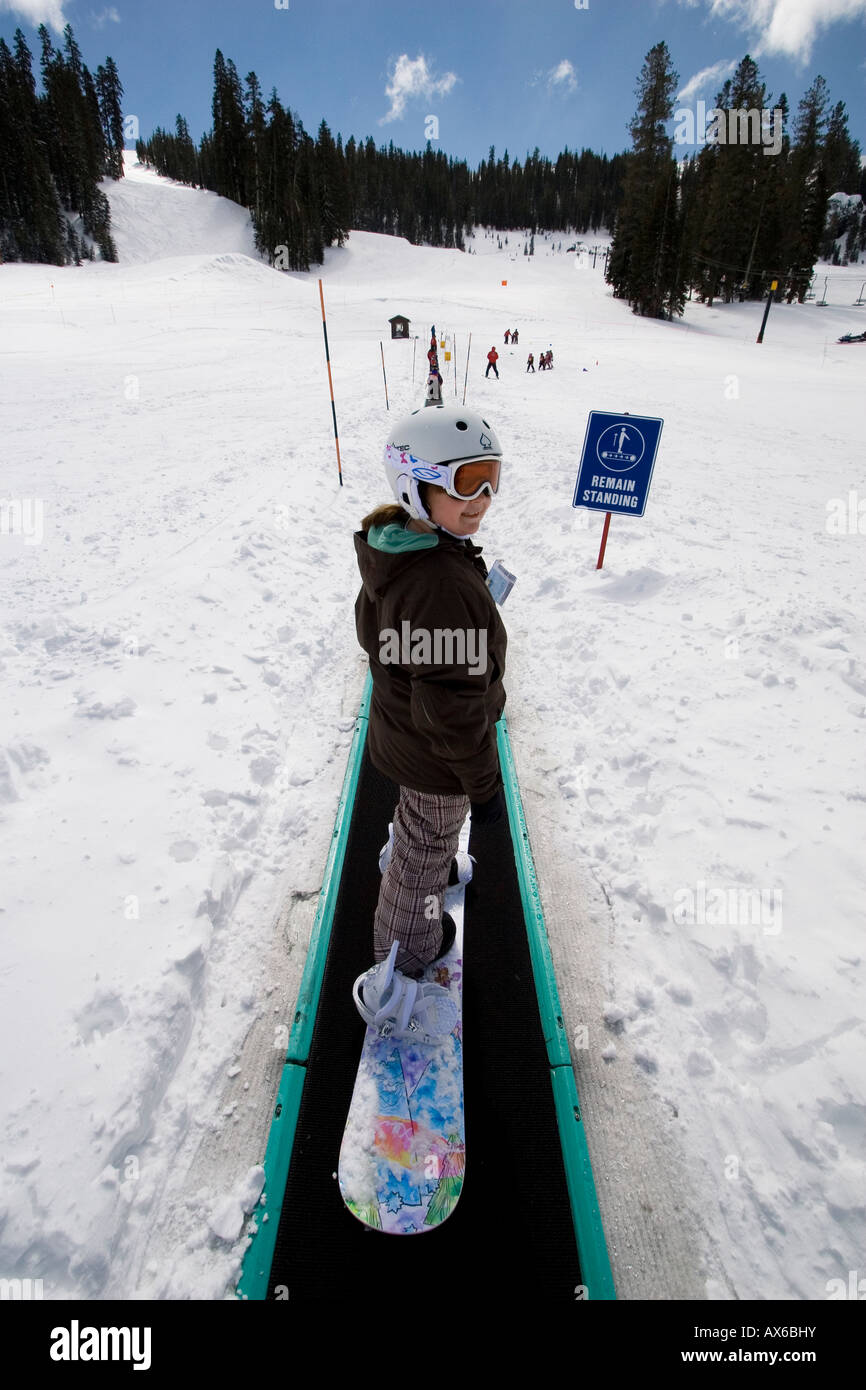 A young snowboarder rides the "Magic Carpet" lift at Bear Valley,  California. (Photo by Kevin Bartram Stock Photo - Alamy