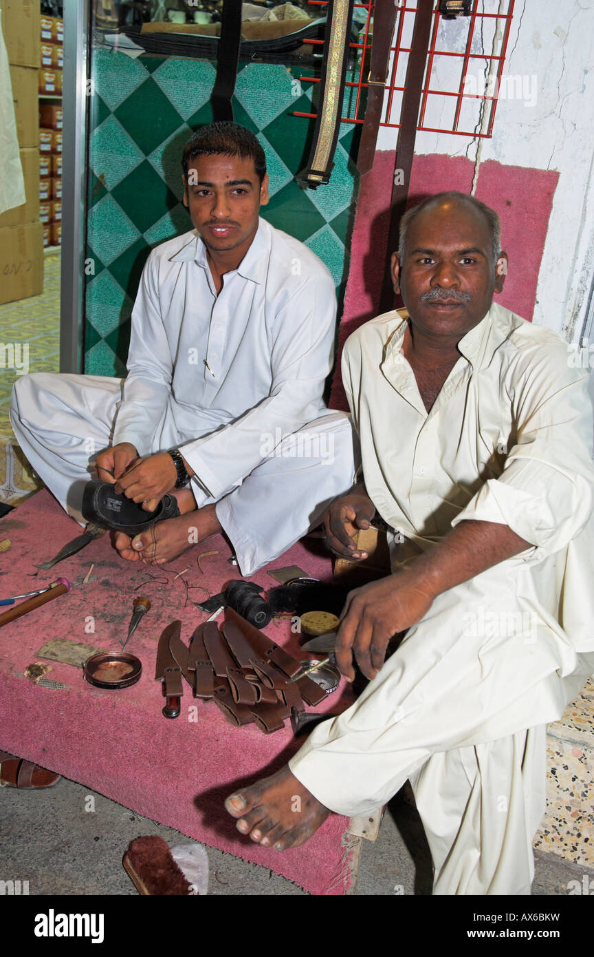 Two men repairing shoes in a souk Muscat Oman Stock Photo Alamy