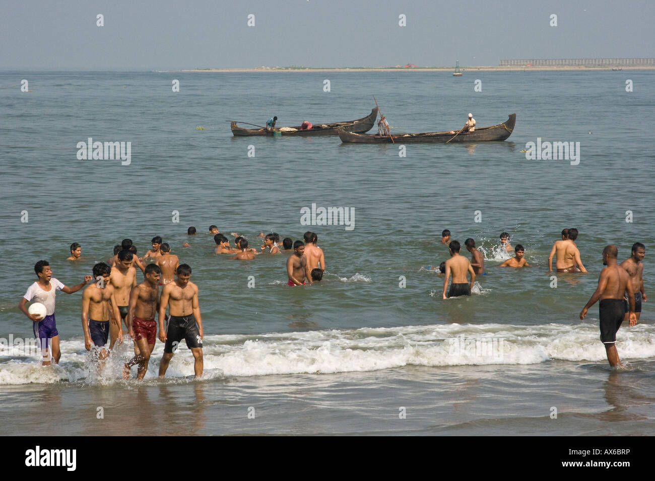 Young Indian Men Enjoying the Ocean Beach in Cochin India Stock Photo