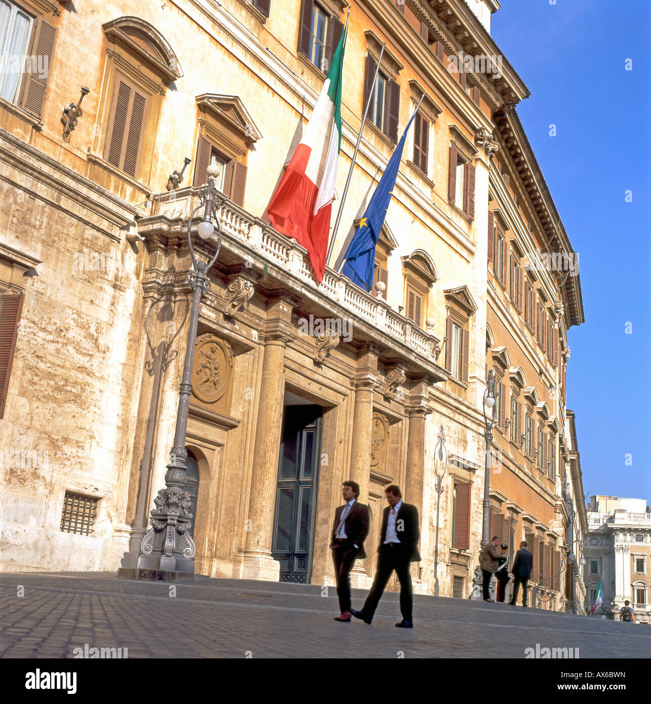 Two men strolling past the Italian Parliament building Palazzo di Montecitorio, in Rome, Italy Stock Photo