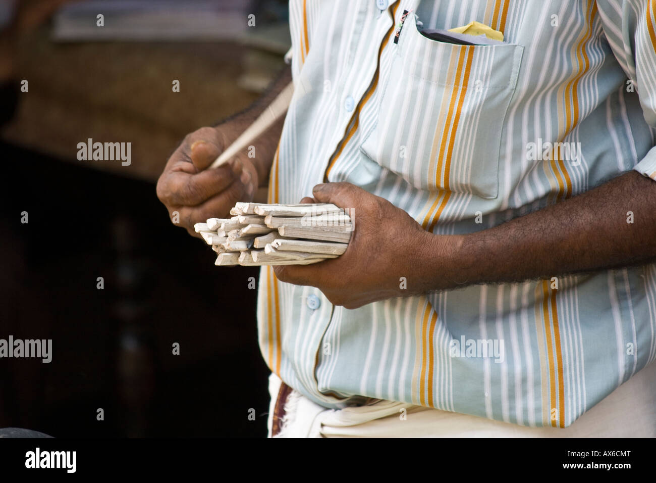 Shopkeeper Counting Sacks by Handing out one Stick Per Load in Cochin India Stock Photo
