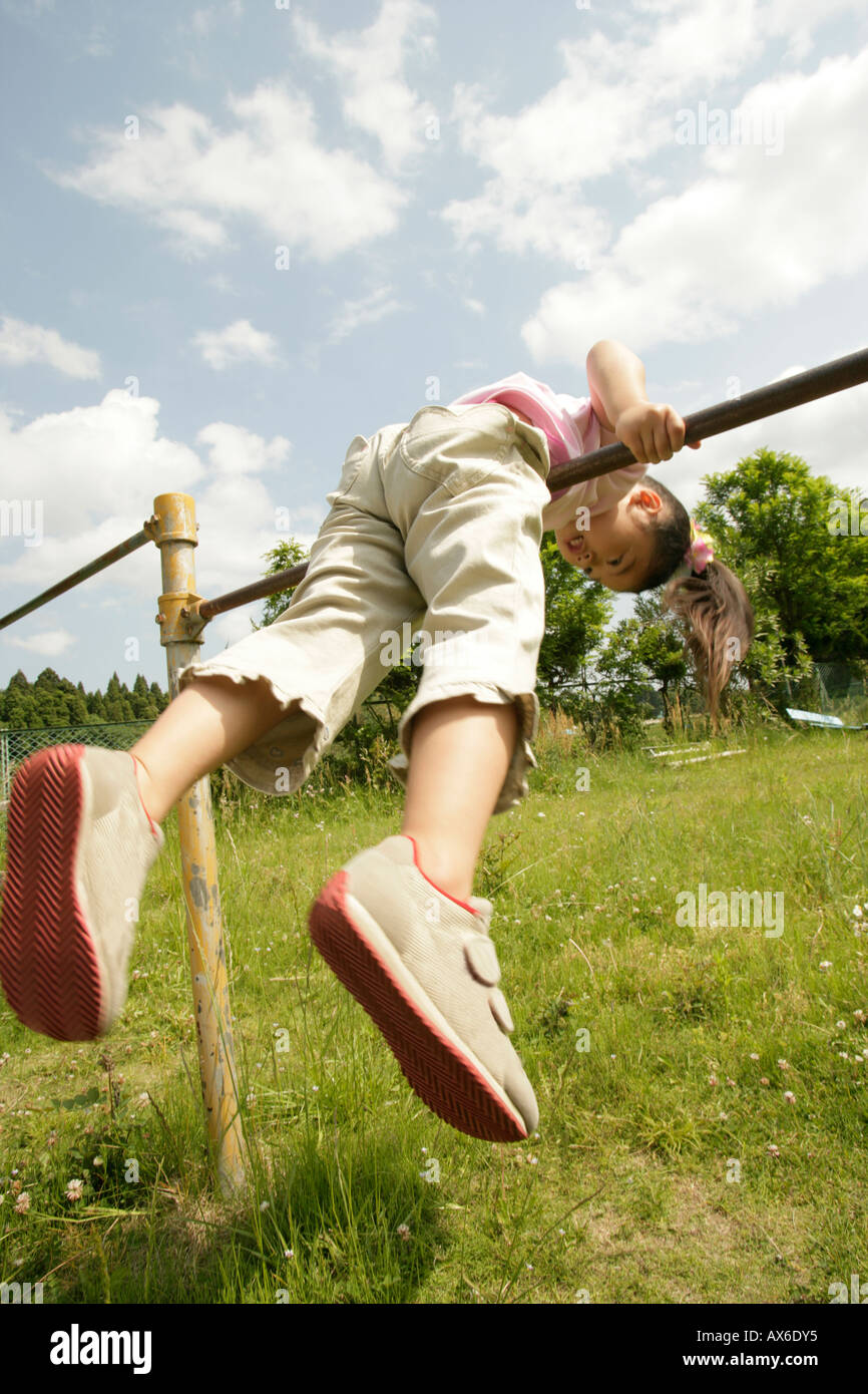 A young girl balancing herself on the rod Stock Photo - Alamy