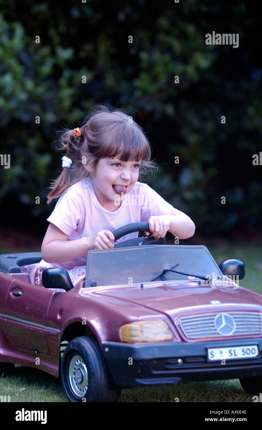 little girl driving toy car