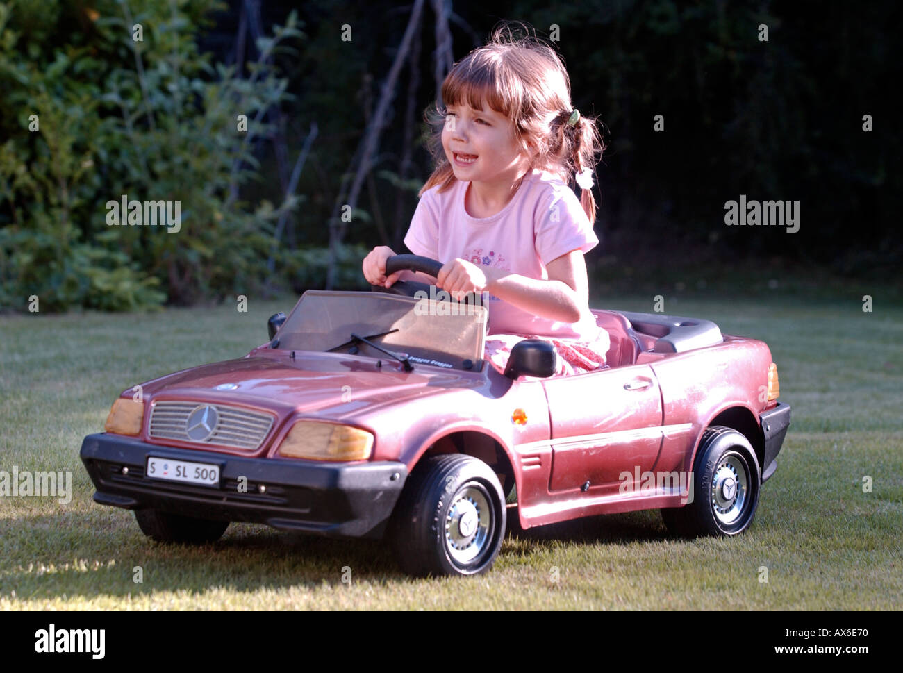 little girl driving toy car