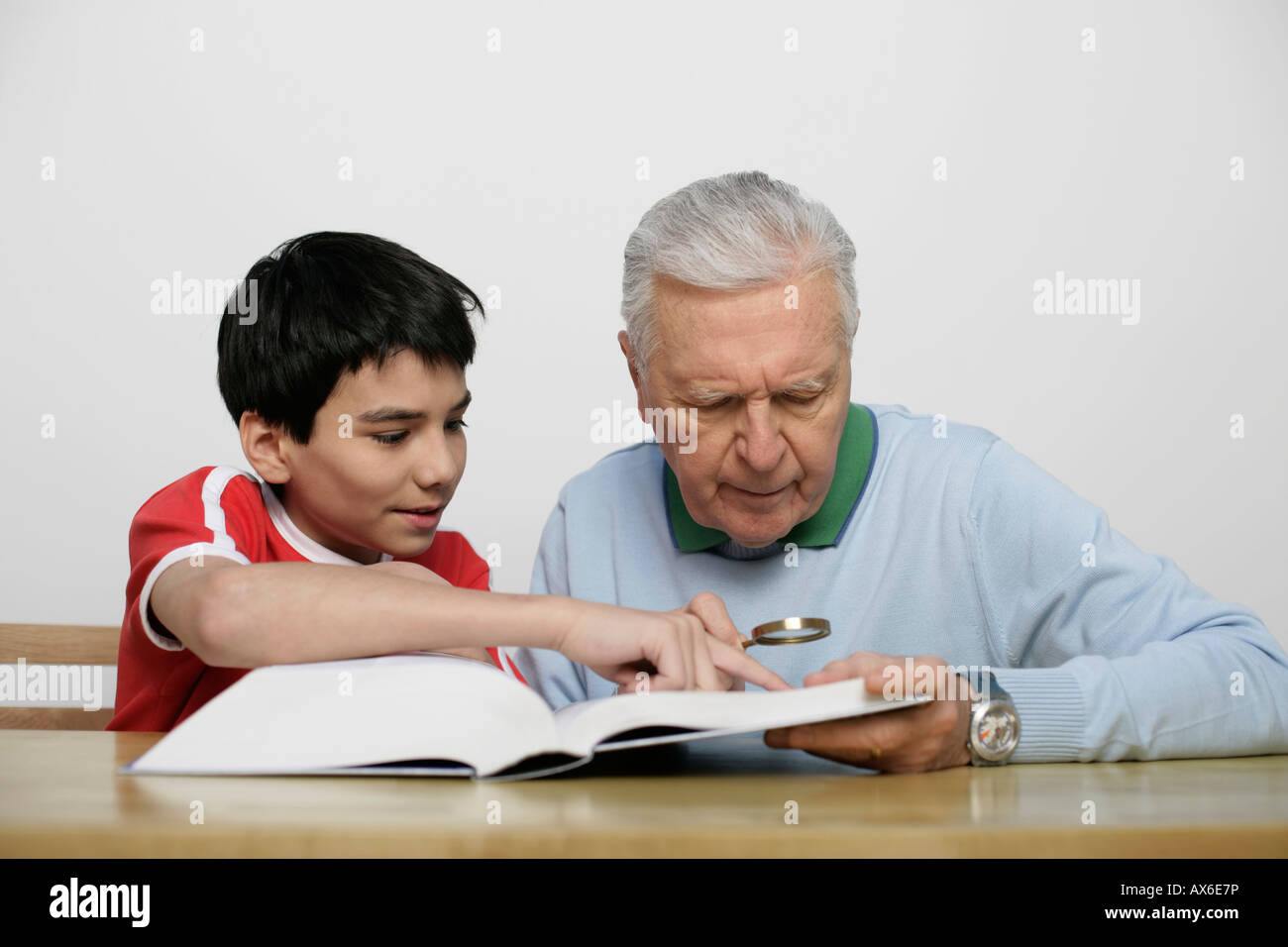 Boy showing grandfather something in a book, fully released Stock Photo