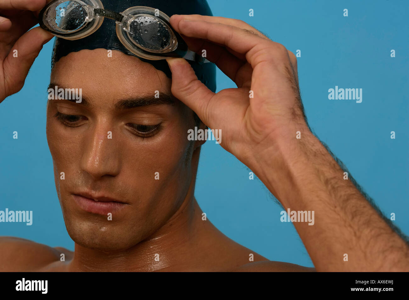 Portrait of a swimmer wearing a bathing cap, putting on his goggles Stock Photo Alamy